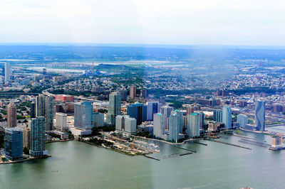 High angle view of city by river against sky