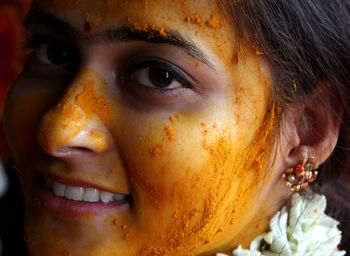 Close-up portrait of woman with turmeric on face