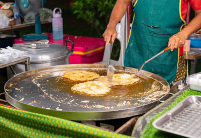 Midsection of man preparing food in kitchen