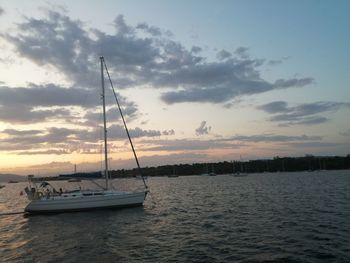 Sailboat sailing on sea against sky during sunset