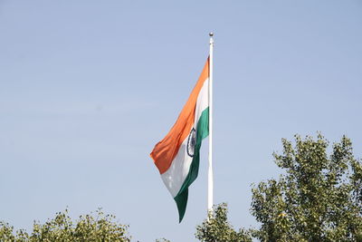 Low angle view of flags against clear sky