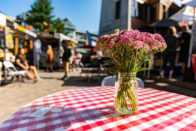 Close-up of flower vase on table at sidewalk cafe