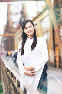 Portrait of young woman standing in city