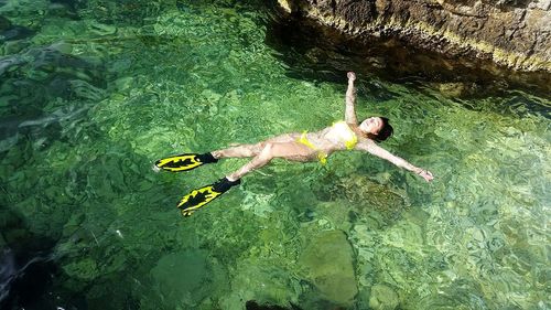 High angle view of carefree woman floating on sea