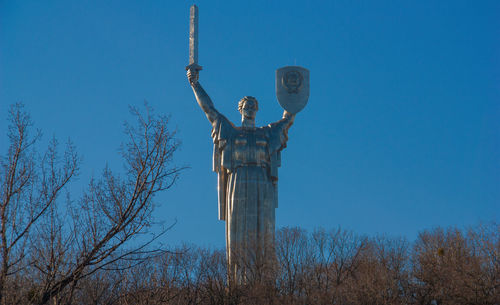 Low angle view of statue against blue sky