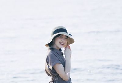 Portrait of a smiling young woman standing on beach