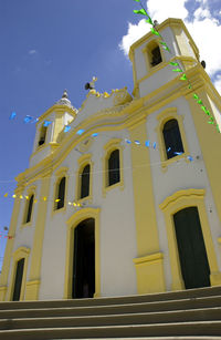 Low angle view of yellow building against sky