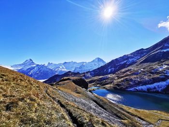 Scenic view of snowcapped mountains against blue sky