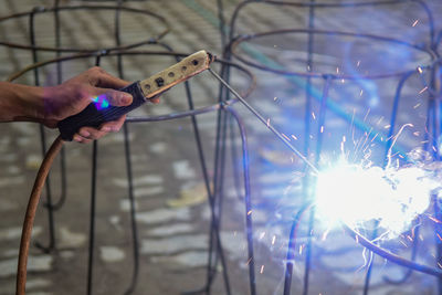 Midsection of person holding illuminated wire