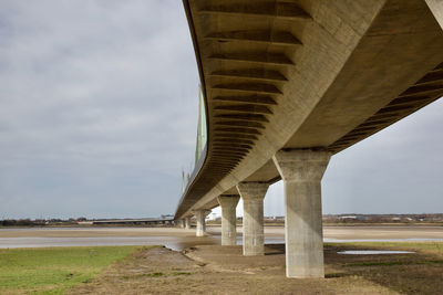 Low angle view of bridge over road against sky