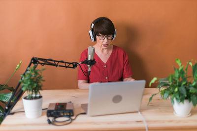 Young woman using laptop while sitting on table