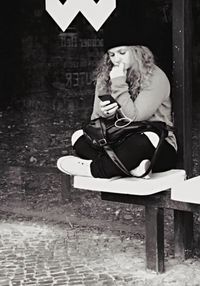 Full length of woman sitting on bench