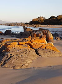 Rocks on beach against clear sky