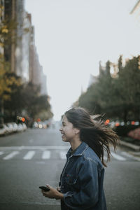 Side view of man using smart phone in city