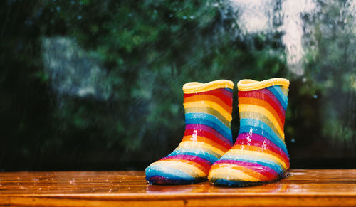 Low section of multi colored shoes on wooden table