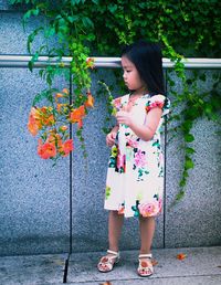 Full length of girl standing against wall