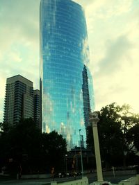 Low angle view of modern building against cloudy sky