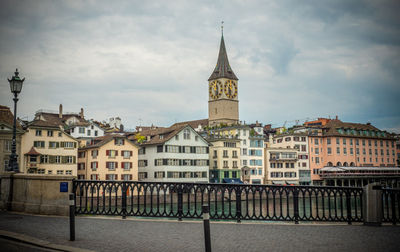 Buildings in city against cloudy sky