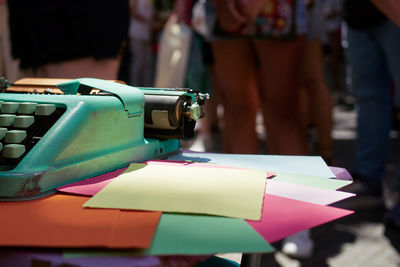 Side view of an antique metal typewriter with blank colored paper.