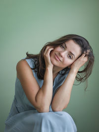 Portrait of young woman sitting on bed at home