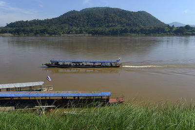 Scenic view of river by mountains against sky