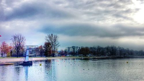 Scenic view of calm lake against cloudy sky