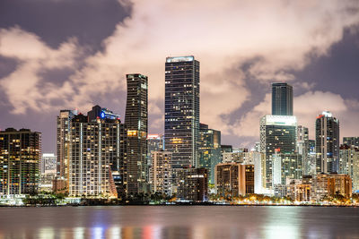 Illuminated buildings in city against sky