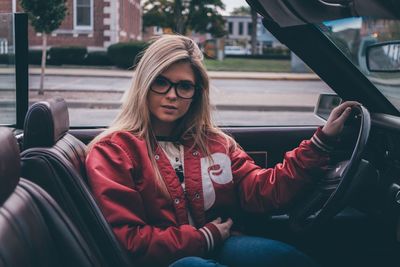 Portrait of young woman sitting in car