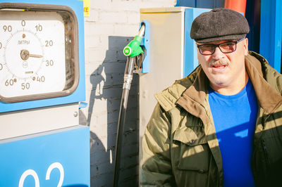 Man standing by machinery at gas station