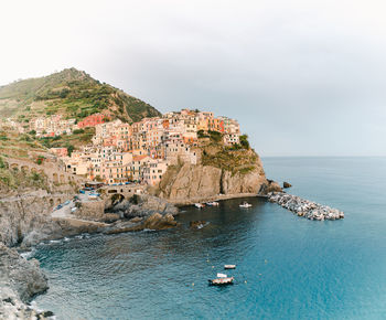 Scenic view of sea by townscape against sky