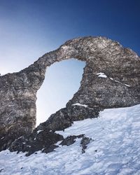 Low angle view of rock against sky during winter