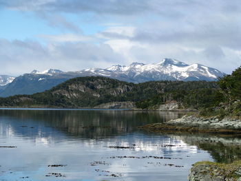 Scenic view of lake by mountains against sky