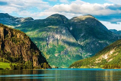 Scenic view of lake and mountains against blue sky