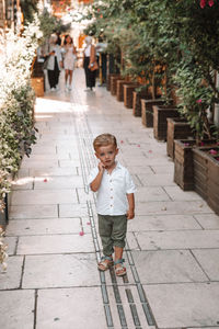 Full length of boy standing on footpath