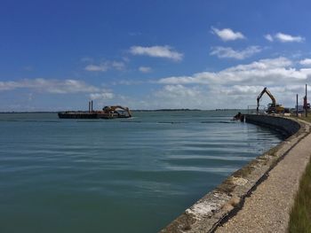 Great salterns quay being demolished by heavy machinery from a floating barge.