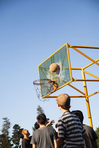 Group of teenage boys playing street basketball