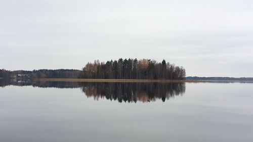 Reflection of trees in calm lake against sky