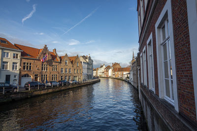 Canal amidst buildings in town against sky