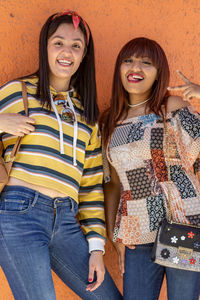 Portrait of cheerful women with straight hair and casual dress showing their 