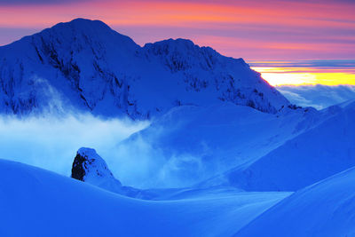 Scenic view of snowcapped mountains against sky during sunset