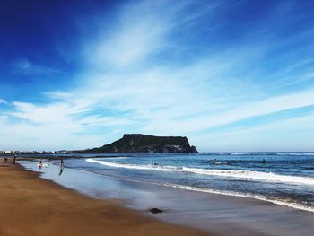 Scenic view of beach against blue sky