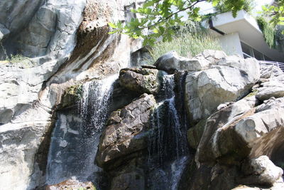Low angle view of waterfall amidst rocks