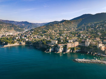 High angle view of townscape by sea against sky