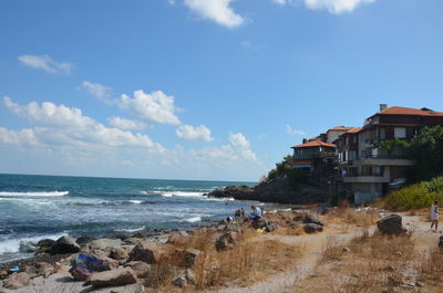 Scenic view of beach and buildings against sky