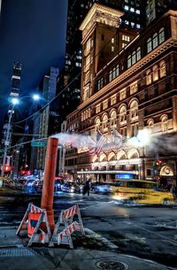 Illuminated building by street at night