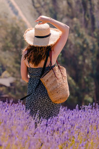 Rear view of woman standing amidst plants