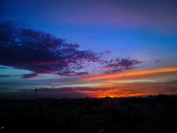 Silhouette buildings against sky at sunset