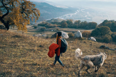 Rear view of woman walking on field