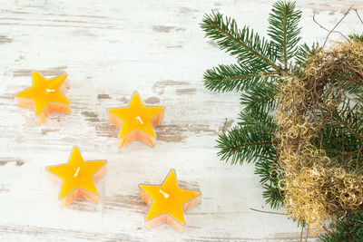 Close-up of christmas tree by star shaped candles on table