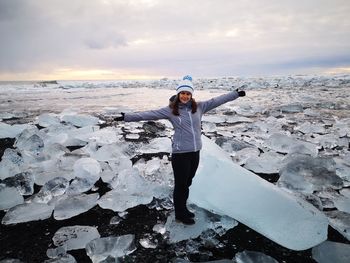 Full length of woman standing on snow against sky